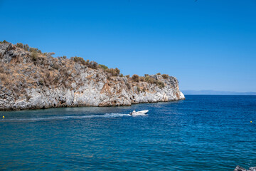 Fototapeta na wymiar Speedboat sails in calm sea at Mani Laconia, Peloponnese. Destination Greece sport activity leisure