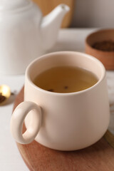 Cup of aromatic buckwheat tea on table, closeup