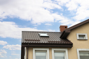 Beautiful house with color roof against blue sky, low angle view