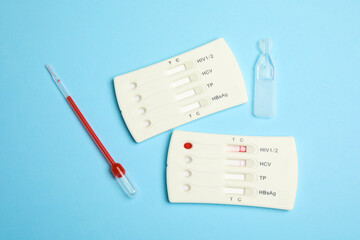 Disposable express hepatitis test kit on light blue background, flat lay