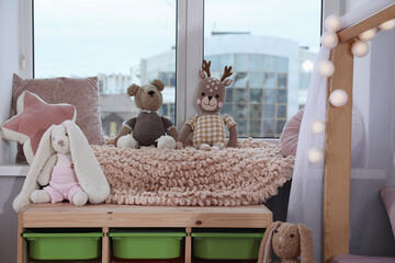 Stylish child room with storage for toys near window