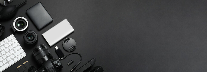 Flat lay composition with camera and video production equipment on black background, space for text. Banner design
