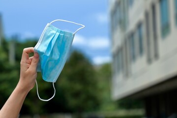 The medical mask in hands takes off from face and raise at outside from residence building, After...