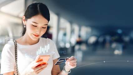 oung adult asian woman consumer pay by creadit card and smartphone with digital stock financial graph