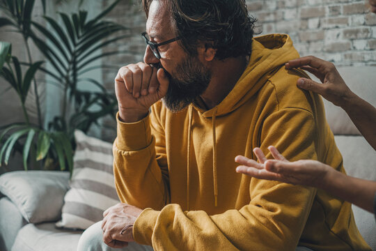 Sad And Worried Man Looking Away While Woman Touching His Shoulder Trying To Speak With Him. Couple And Love Problems. Bad Relationship Moment. People And Depression. Husband And Wife Problem At Home