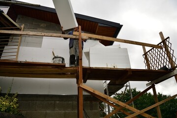 Mason works on thermal insulation of the wall with polystyrene - 514786866