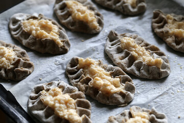 Homemade karelian pies (fin: karjalanpiirakka) - traditional Finnish snack including rye bread shell filled with boiled rise. Delicious savory food often eaten with some egg butter. Color closeup.