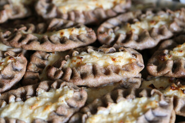 Homemade karelian pies (fin: karjalanpiirakka) - traditional Finnish snack including rye bread shell filled with boiled rise. Delicious savory food often eaten with some egg butter. Color closeup.