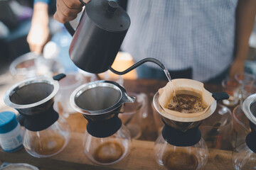 Barista using kettle pour hot water making drip coffee