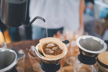 Barista using kettle pour hot water making drip coffee
