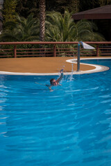Senior adult swims in the pool. The concept of a healthy active lifestyle in old age