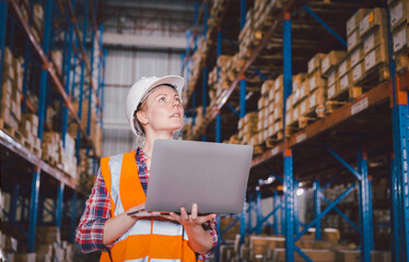One logistic woman using computer laptop checking inventory stock in warehouse