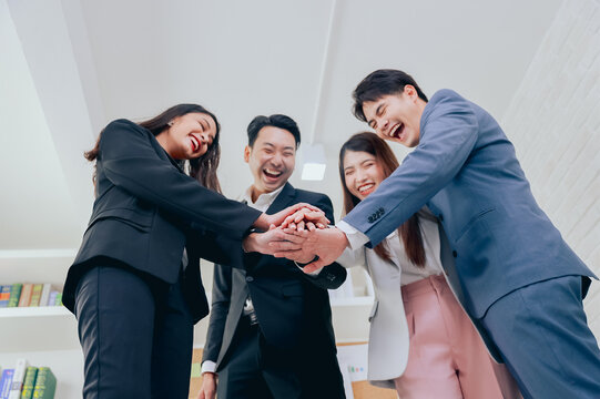 Group of young colleague businessman and businesswoman celebrate successful together in working office, Hands join together teamwork concept