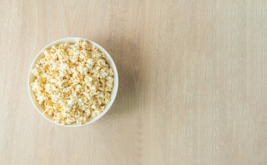 popcorn on the wooden table. flat lay of popcorn in bowl. top view. copy space for text