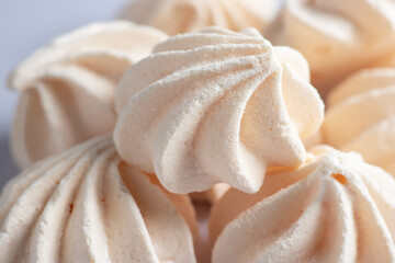 Small meringues in a white dish. Macro shot. Copy space