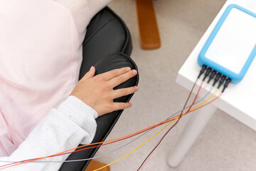 Relaxed arm of a patient connected to a device during a biofeedback session