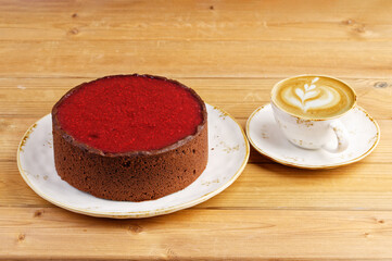 Homemade raspberry and strawberry cheesecake and cup of coffee cappuccino on wooden table.