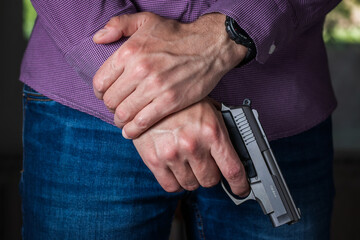 Man holding pistol in the hand in front of