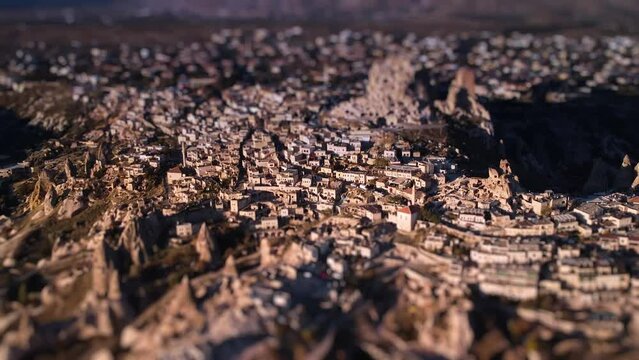 Tilt shift footage of Uchisar castle and ancient city built next to it in Cappadocia province. Drone aerial landscape of the national nature heritage with unusual fairy chimneys rocks and a stone town