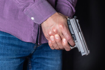 Gun control concept. Armed man holds pistol in hand