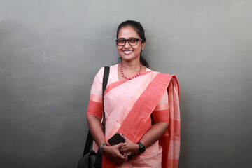 Portrait of a happy woman of Indian ethnicity wearing traditional dress sari and holding a mobile
