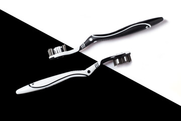 Two toothbrushes on a black and white background. The concept of oral hygiene, dental care, a collage of toothbrushes