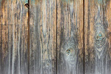 The texture of an old weathered wooden wall with remnants of blue paint. Wooden background with a space to copy.