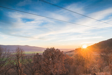 A scenic sunset over a wooded area.