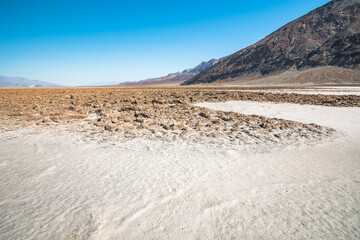 Salt flats and mud cracks in Death Valley National Park. Badwater Basin and Black Mountains