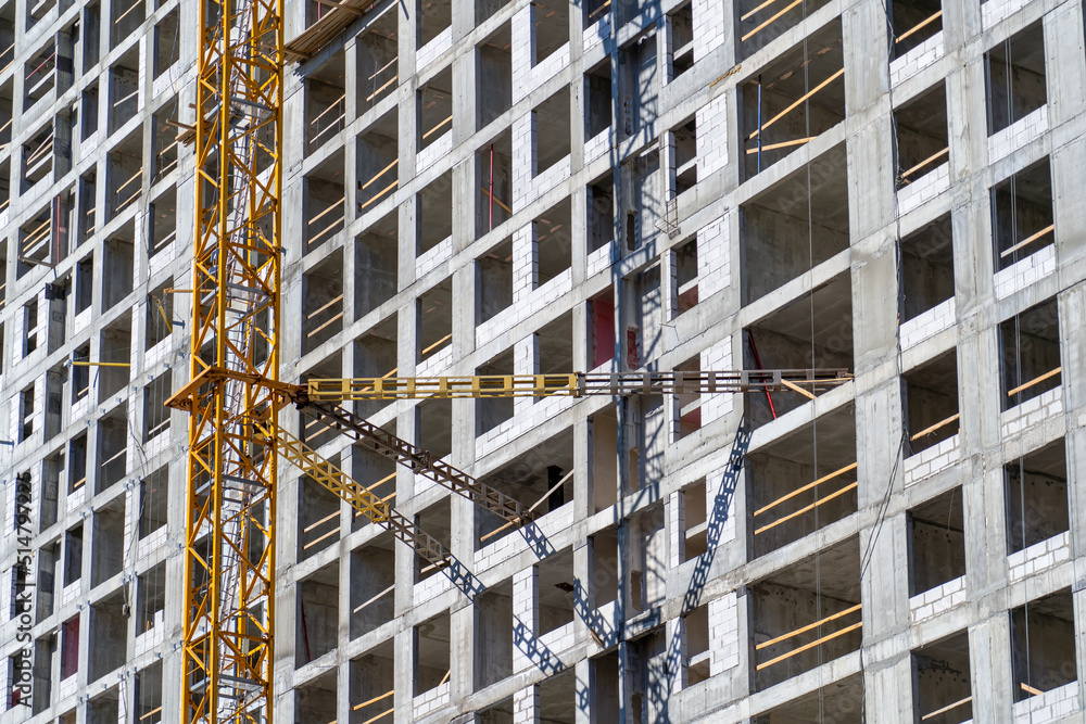 Poster view of frame part of metallic crane machinery attachment at windows of new residential building con