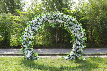 Decoration wedding arch with white flowers on a green natural background. Beautiful wedding...