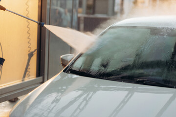 Close-up of a car under the water jet during the washing process on a self service car wash