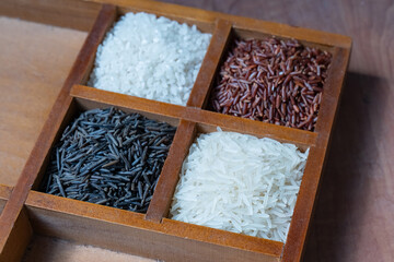 set of four wooden cells with red, white and black rice, bassmati rice background