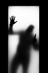 black silhouette on a light background, in the window with a knife, the horror of the appearance of...