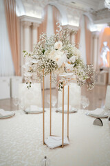 Wedding centerpieces, with metal vase and white fresh flowers arrangements.