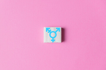transgender symbol on wooden block on pink background. Transgender rights concept