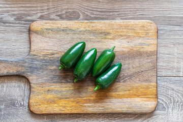 jalapeno pepper green hot on a wooden cutting board top view