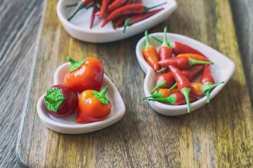 assorted red fresh hot peppers on a background of chili in white plates selective focus