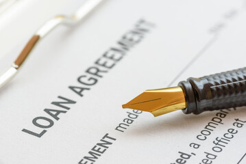 Business loan agreement or legal document concept : Fountain pen on a loan agreement paper form....