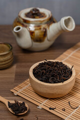 Dried tea leaves in a wooden cup on the table. Good quality Chinese tea with good smell.