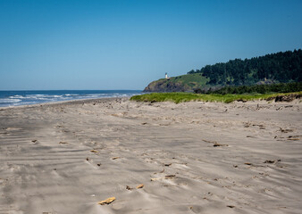 Beach with lighthouse in the distance at Cape Disappointment in Oregon