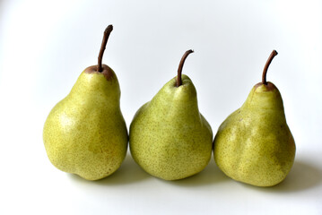 Three green juicy pears on a white background