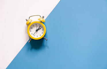 Yellow alarm clock on colored background isolated, flat lay.