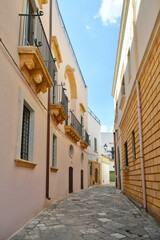 Fototapeta na wymiar A narrow street between the old houses of Uggiano, a medieval town in the Puglia region of Italy.