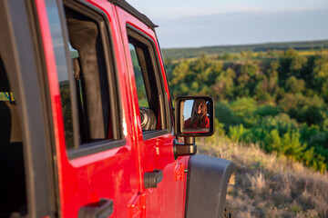 A young woman driving an SUV in the countryside.