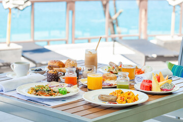 Breakfast in tropical hotel with sea view. Buffet food in restaurant in modern resort. Concept of...