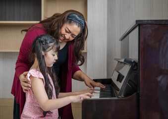 Mother teaching daughter to play the piano,Happy child of learning the piano.