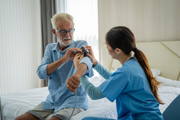 Fototapeta premium Nurse measures blood pressure to seniors patients at home,Concept of Health Care,Medical Consultant.