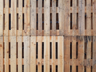 Pallet wall background. Eco-friendly full frame pallets. Wood Pallets plank texture background. Wall with overlapping pallets. Recycle crafts.