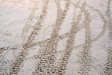 trail of motorcycle tires in the sand.
